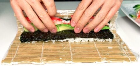 Roll one edge of the rice and nori over the fillings.