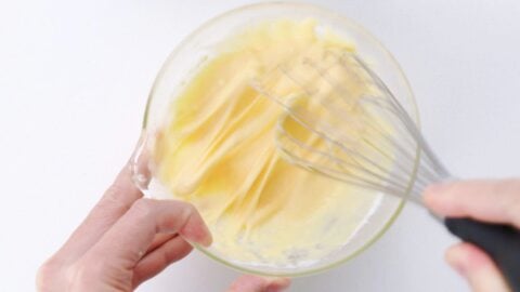 Whisking egg, water and flour batter in a bowl until free of lumps.