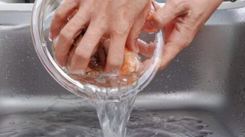 Rinsing shrimp with cold water.