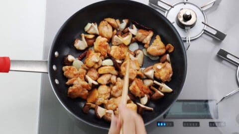 Stir-frying garlic, chicken, and mushrooms.