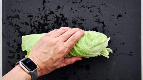 Rolled cabbage leaves ready to shred with a knife to make a salad.