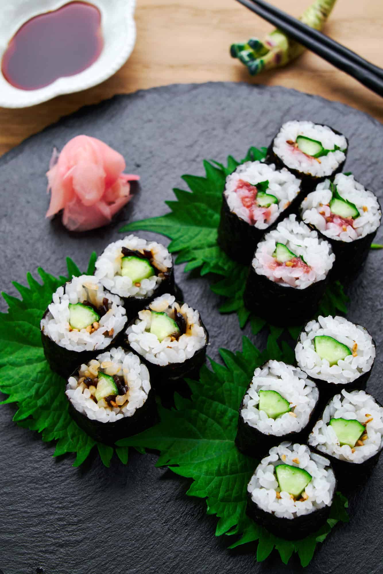 3 variations of Kappa Maki sushi rolls or cucumber sushi on a black plate with crispy cucumber and seasonings rolled with sweet and tangy sushi rice, and crisp nori.