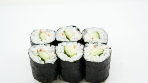 Close-up shot of the cucumber sushi roll, emphasizing the texture of the sushi rice and the crisp cucumber.