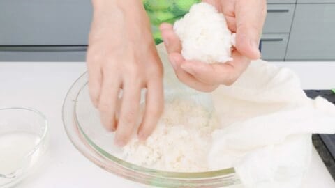 Scooping 80 grams of sushi rice for making a sushi roll.