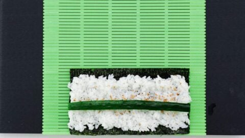 Cucumber and sushi rice and a nori sheet.
