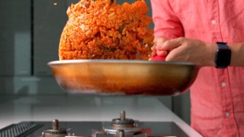 Tossing kimchi fried rice in a frying pan.