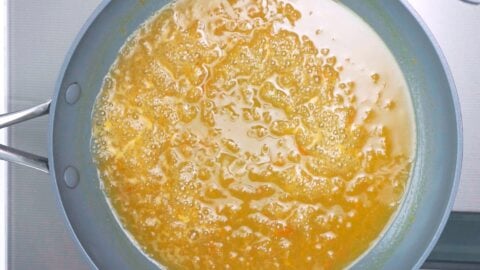 Orange sauce for orange chicken simmering in a pan.