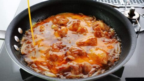 Egg added to a pan of oyakodon.