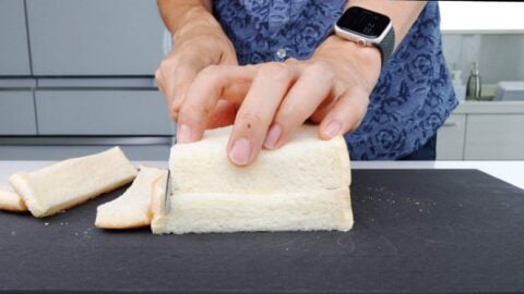 Slicing crusts off sandwich bread to make panko.