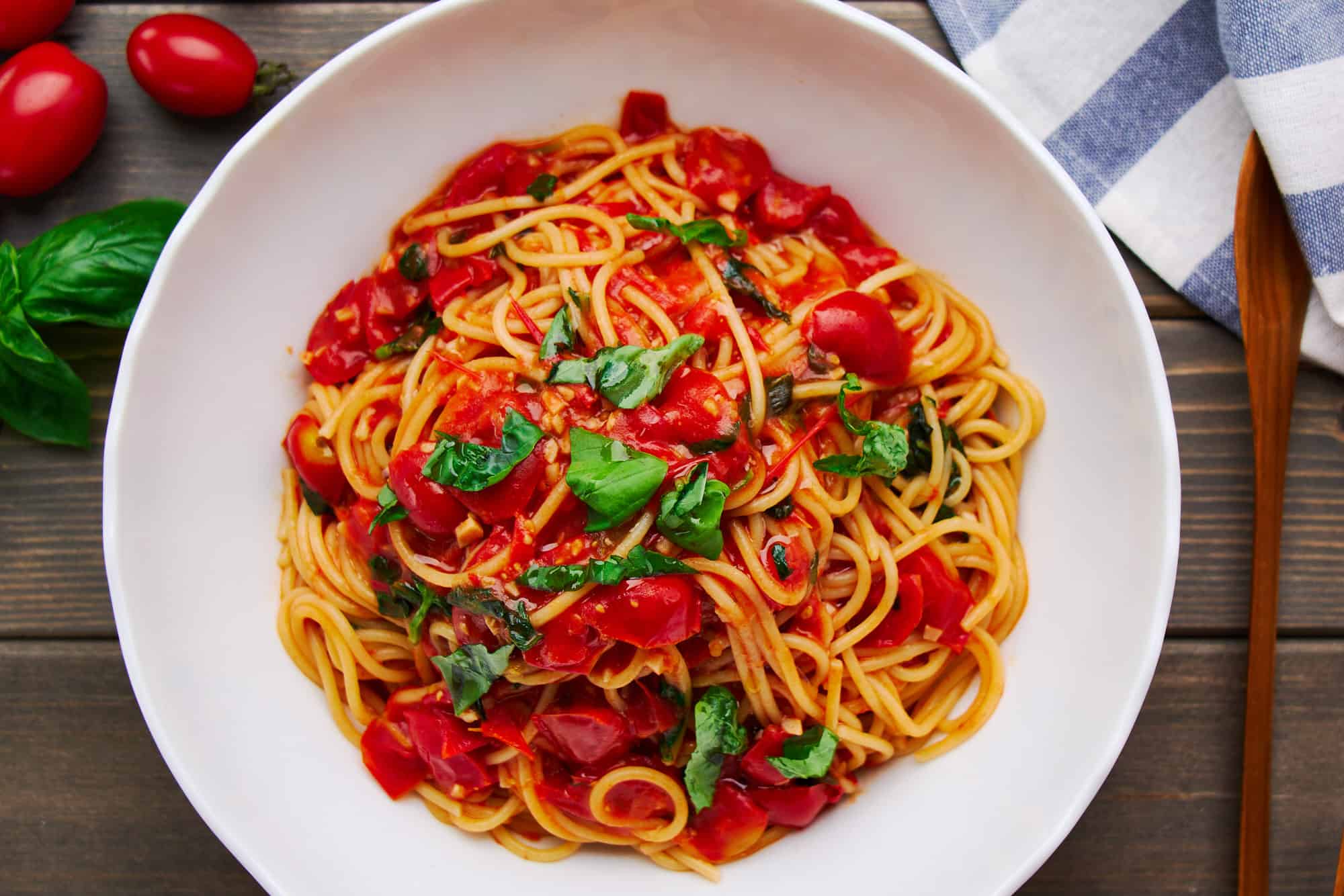 Overhead shot of a bowl of the best Pasta Pomodoro, highlighting the vibrant red tomato sauce and fresh basil married with al dente spaghetti.