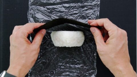 Wrapping onigiri rice ball with nori.
