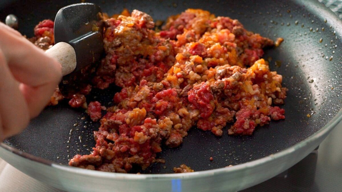 Ground beef and pork that have been added to the caramelized aromatics for making spaghetti sauce.