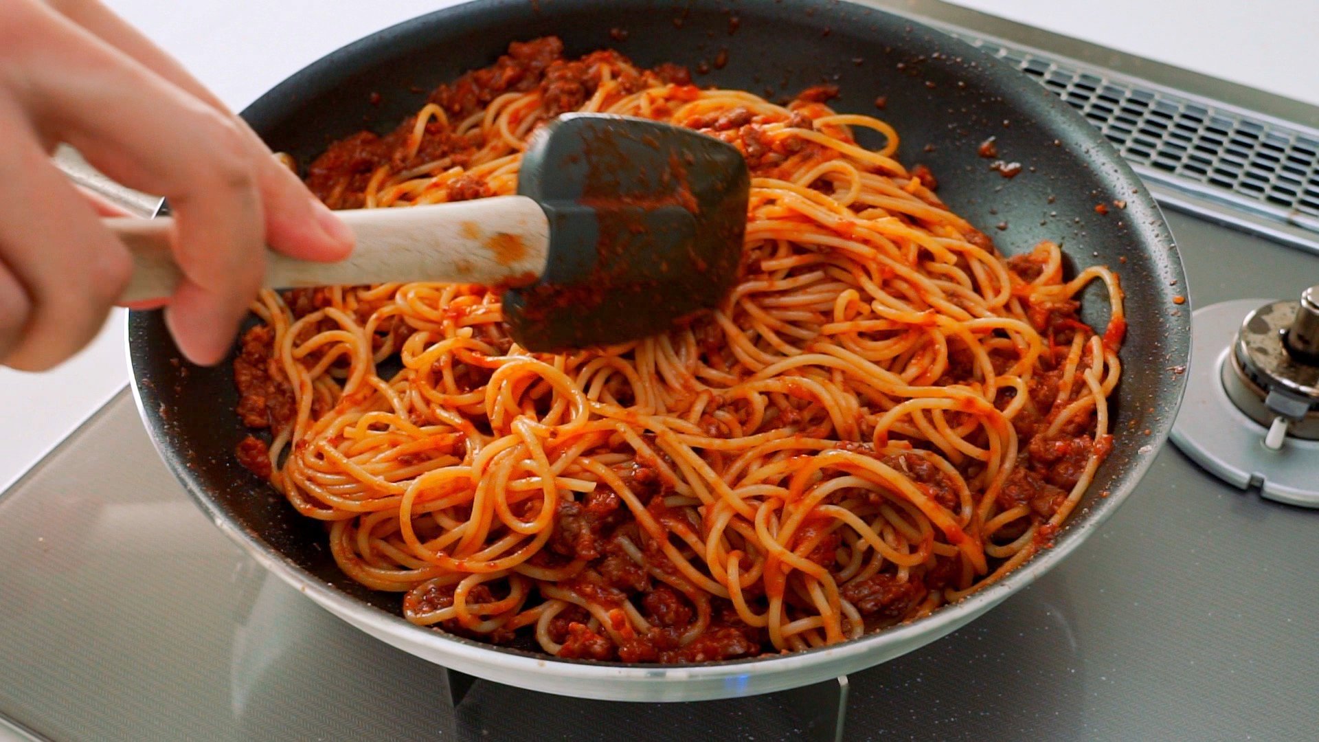 Meat sauced tossed together with boiled spaghetti noodles.r