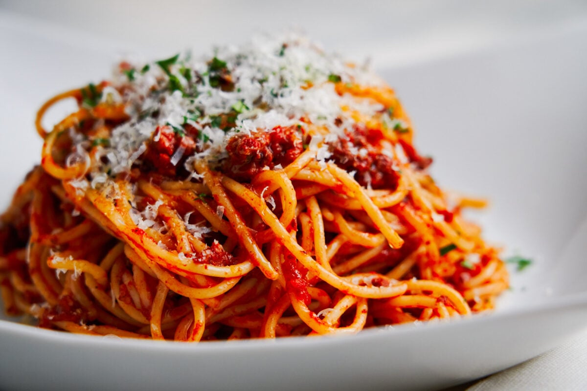 A mound of the best quick spaghetti with meat sauce dusted with parmesan cheese.