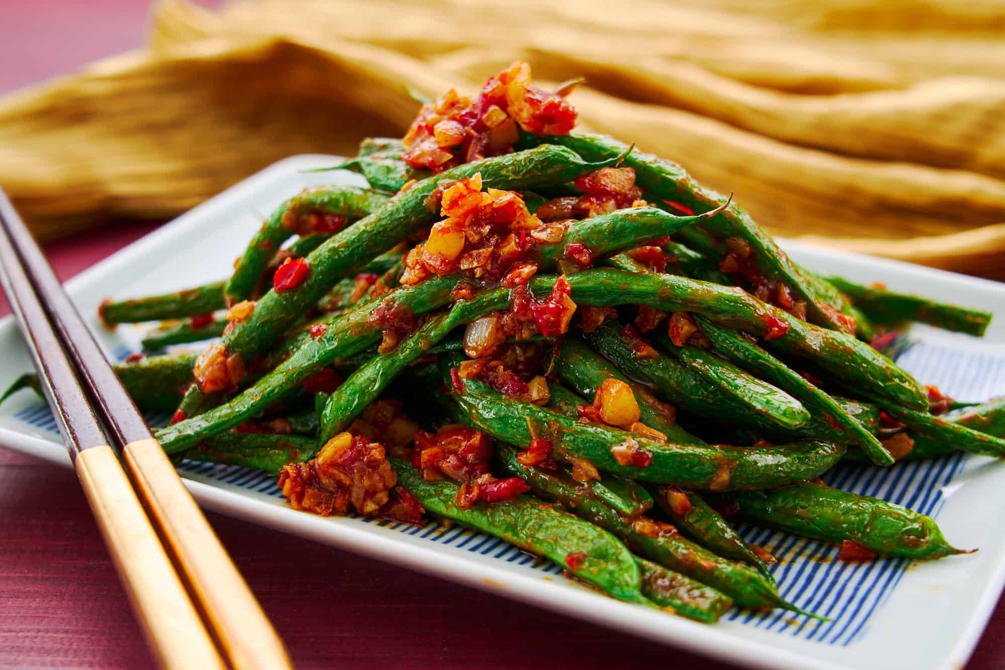 Mound of green beans stir fried with garlic and chili paste. An easy vegan Chiense stir-fry.