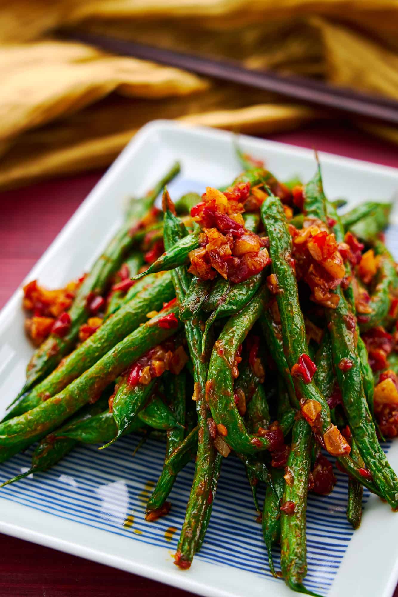 A plate of vibrant green beans stir-fried with chili garlic sauce. An easy 3 ingredient Chinese stir fry.