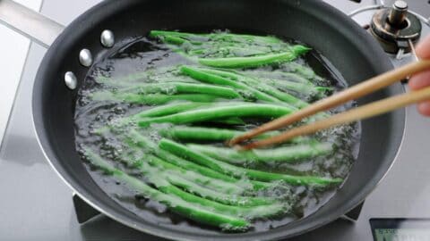 Oil blanching green beans.