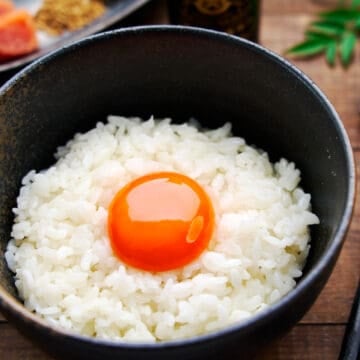 A beautiful golden orb of egg yolk atop a steaming bowl of white rice makes for a delicious Japanese comfort food called Tamago Kake Gohan.