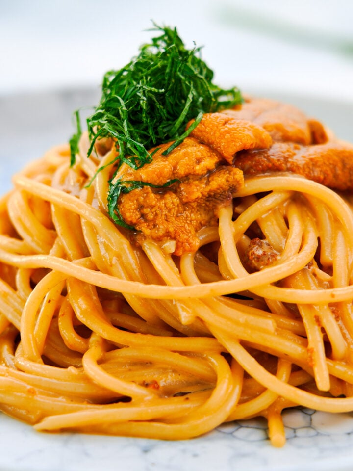 Creamy uni pasta with spaghetti, garnished with fresh uni and green shiso.